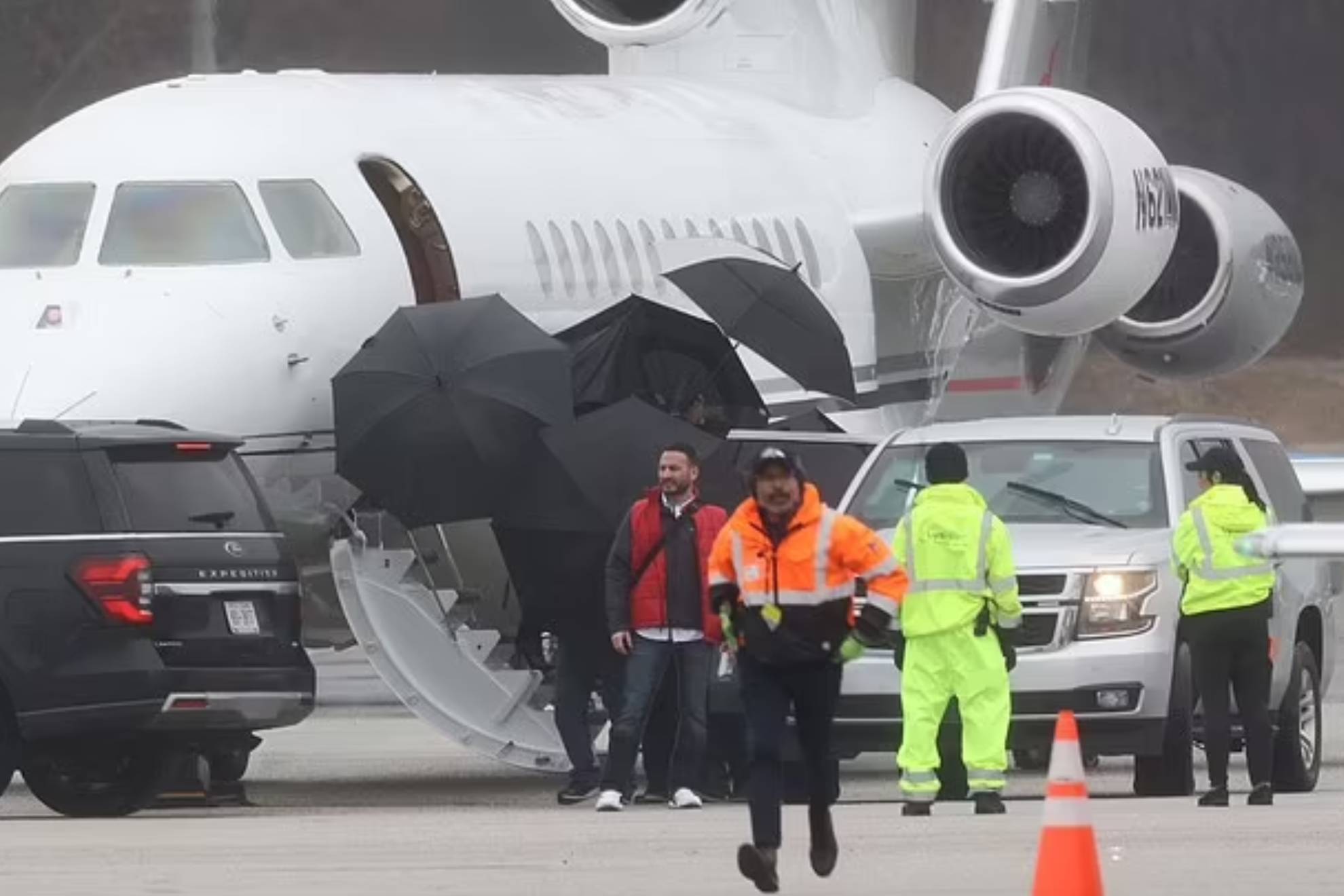 Los guardias de seguridad tapando con paraguas el avión de Taylor Swift