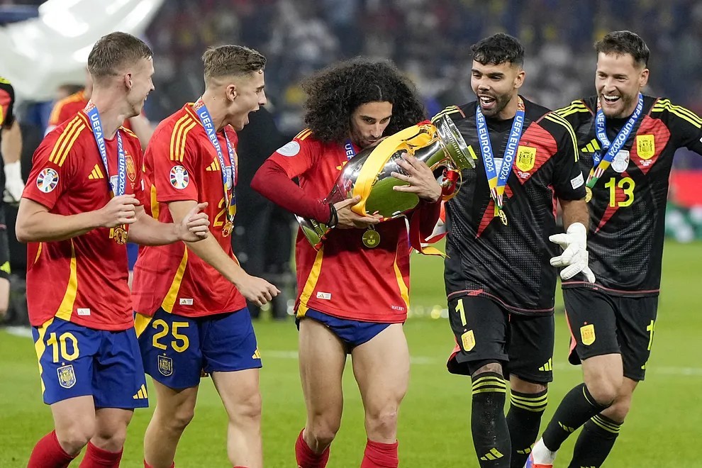 Marc Cucurella sujetando el ttulo de la Eurocopa rodeado de varios de sus compaeros